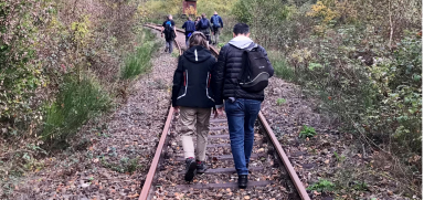 Gruppe von Teilnehmenden unterwegs auf einem stillgelegten Gleis während einer Outdoor-Expedition